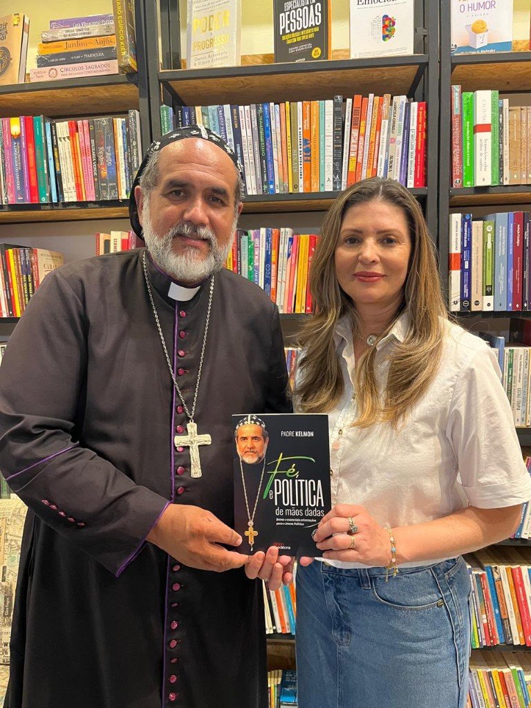 Padre Kelmon com o livro Fé e Política de Mãos Dadas em livraria